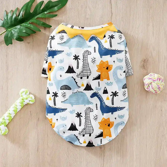Cute dog shirt with colorful dinosaur print on wooden surface with green bone toy and rope ball