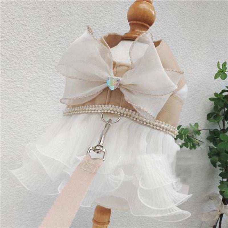 Elegant white pet harness dress with large bow and pearl trim on mannequin