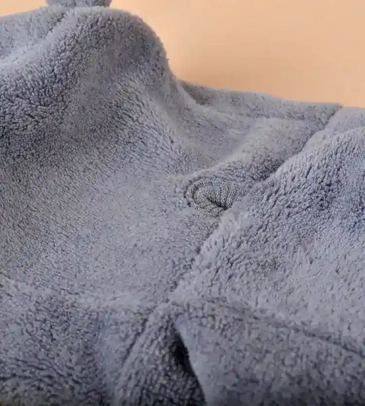 Close-up of soft gray fleece fabric with visible textured fibers and stitching detail