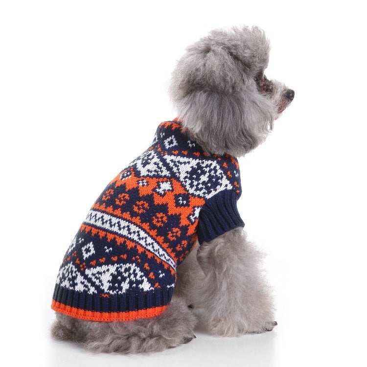 Gray poodle wearing a navy, orange, and white patterned knit sweater sitting on white background