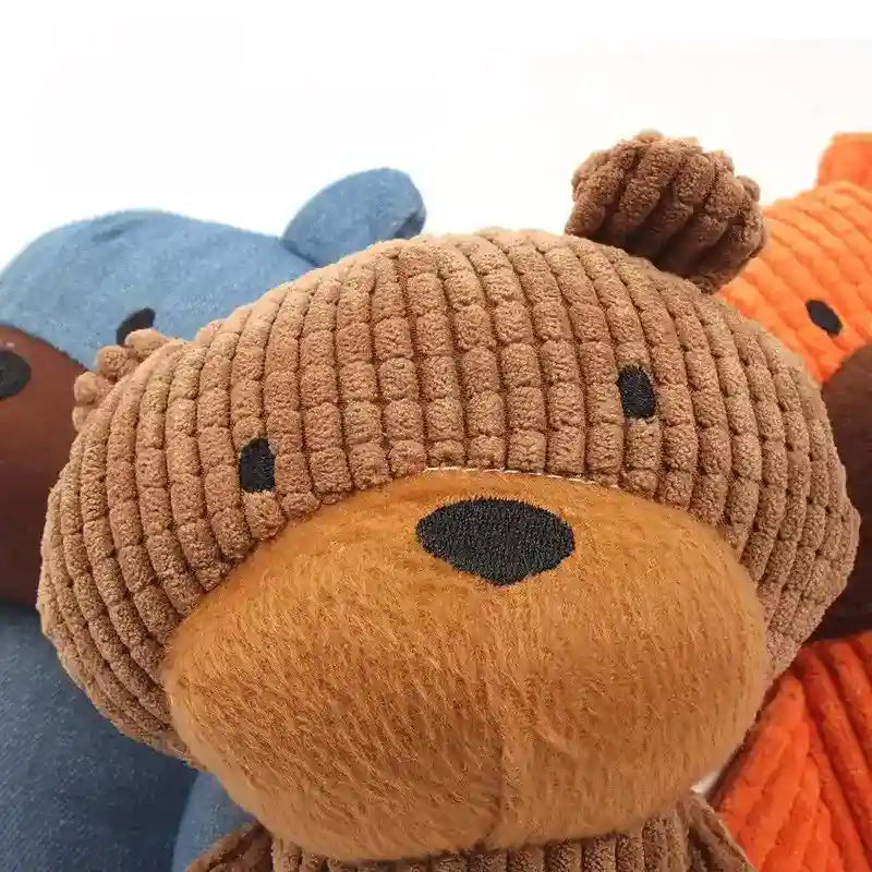 Close-up of three plush teddy bears in brown, blue, and orange with soft textured fabric