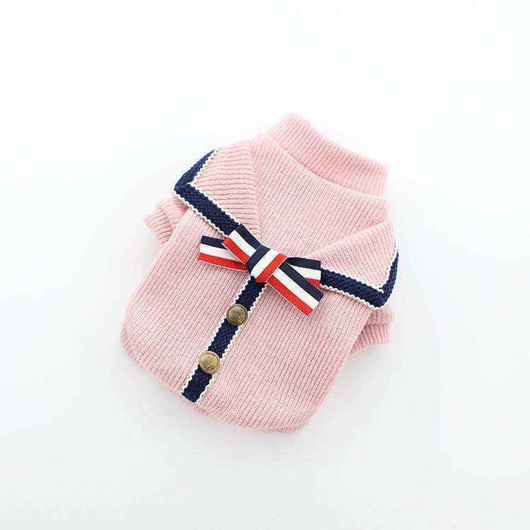 Pink ribbed knit dog sweater with navy trim, gold buttons, and red-white-blue striped bow