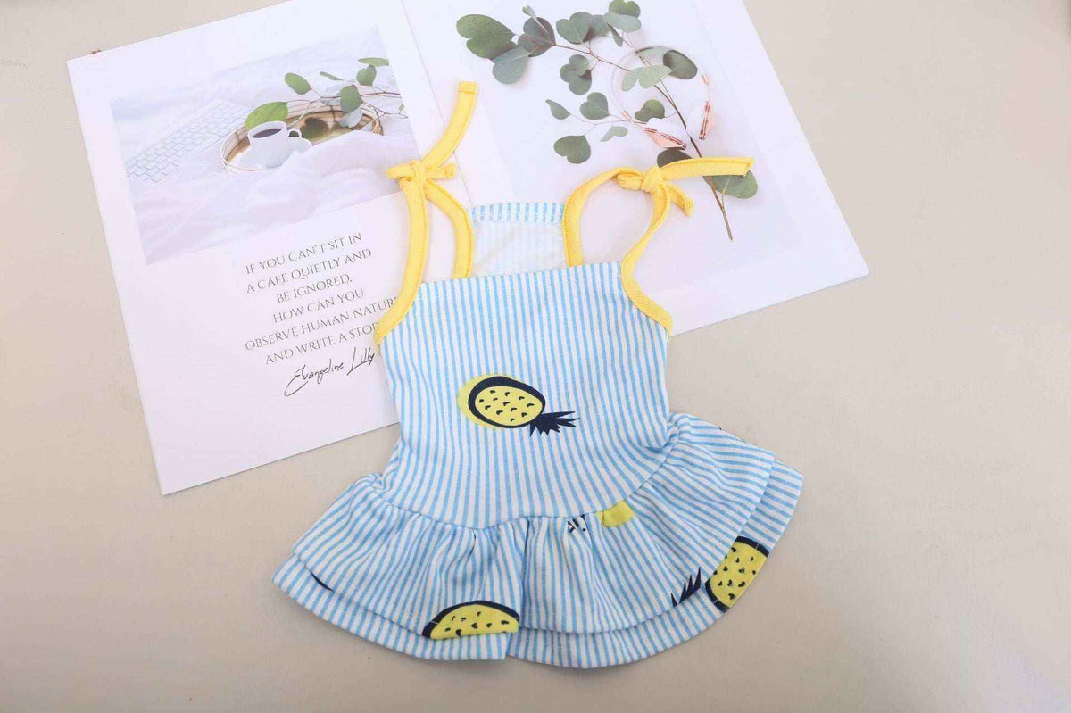 Blue and white striped baby dress with yellow pineapple prints and yellow straps on beige background