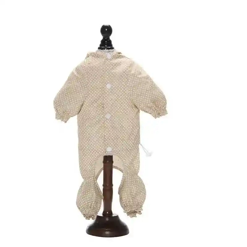 Beige and white polka dot baby onesie with long sleeves and gathered cuffs on display stand