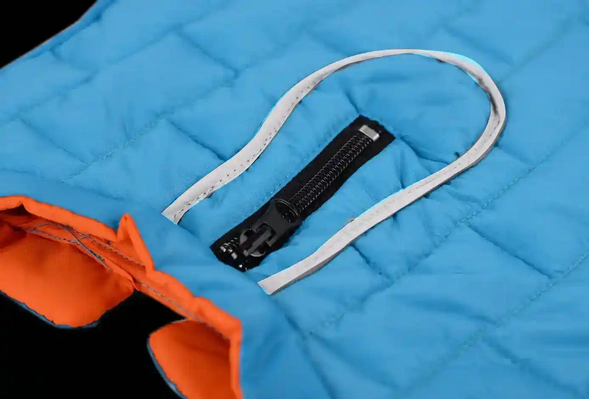 Close-up of blue quilted fabric with black zipper and orange lining detail