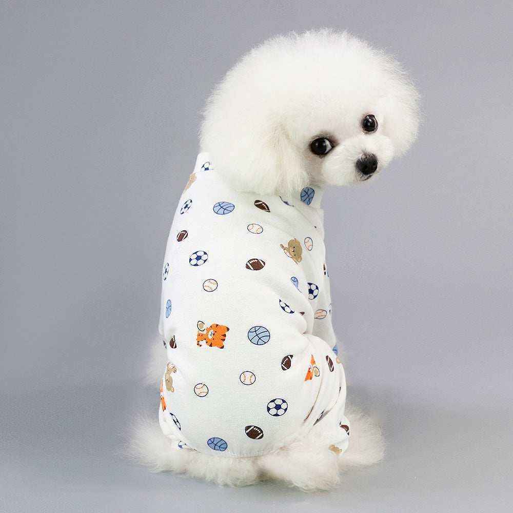 White fluffy dog wearing cute sports-themed pajama with balls and animals on gray background
