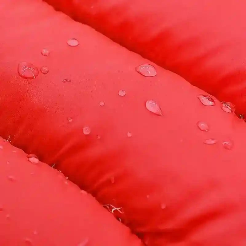 Close-up of red padded waterproof fabric with water droplets on surface