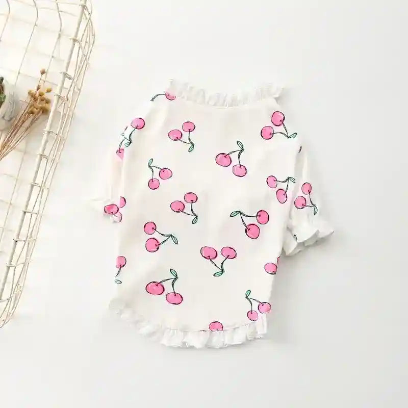 White baby blouse with pink cherry print and ruffled edges on a white background
