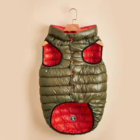 Olive green and red padded dog jacket with hood and button closure on a wooden hanger