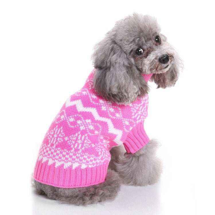 Gray poodle wearing a pink and white patterned knit sweater, sitting and looking back