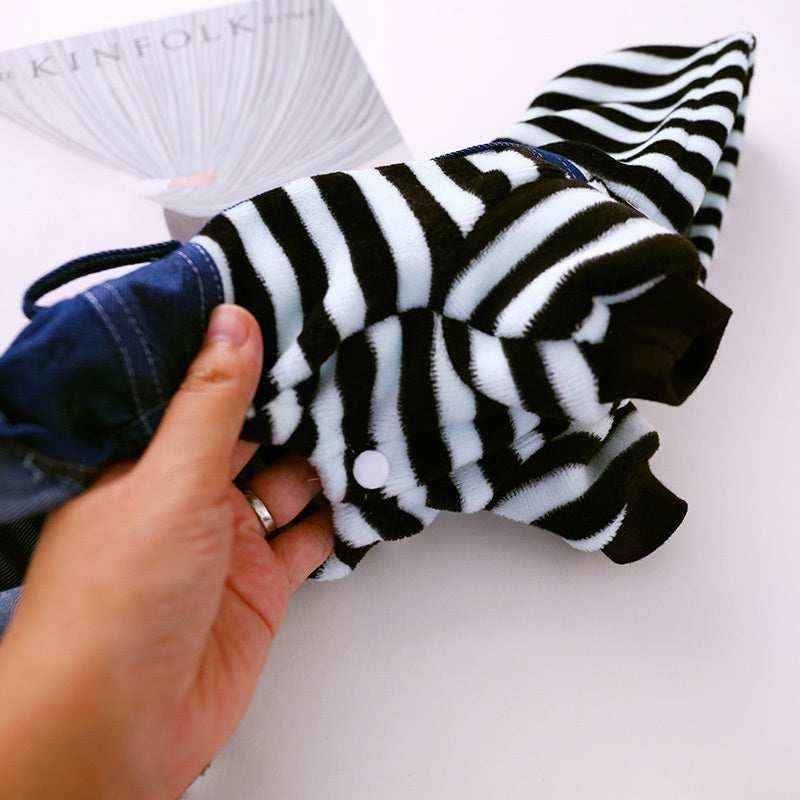Hand holding black and white striped fleece pet hoodie with navy blue bottom and snap button closure