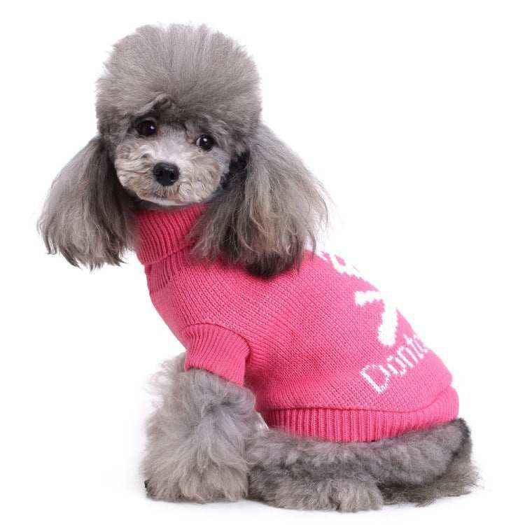 Gray poodle wearing pink knit dog sweater with white pattern on white background