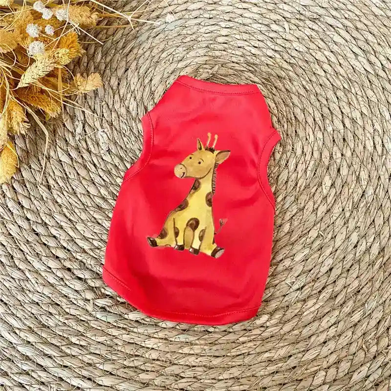 Red pet tank top with cute cartoon giraffe print on woven round mat with dried flowers