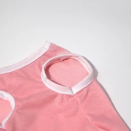 Close-up of pink sleeveless pet shirt with white trim on white background