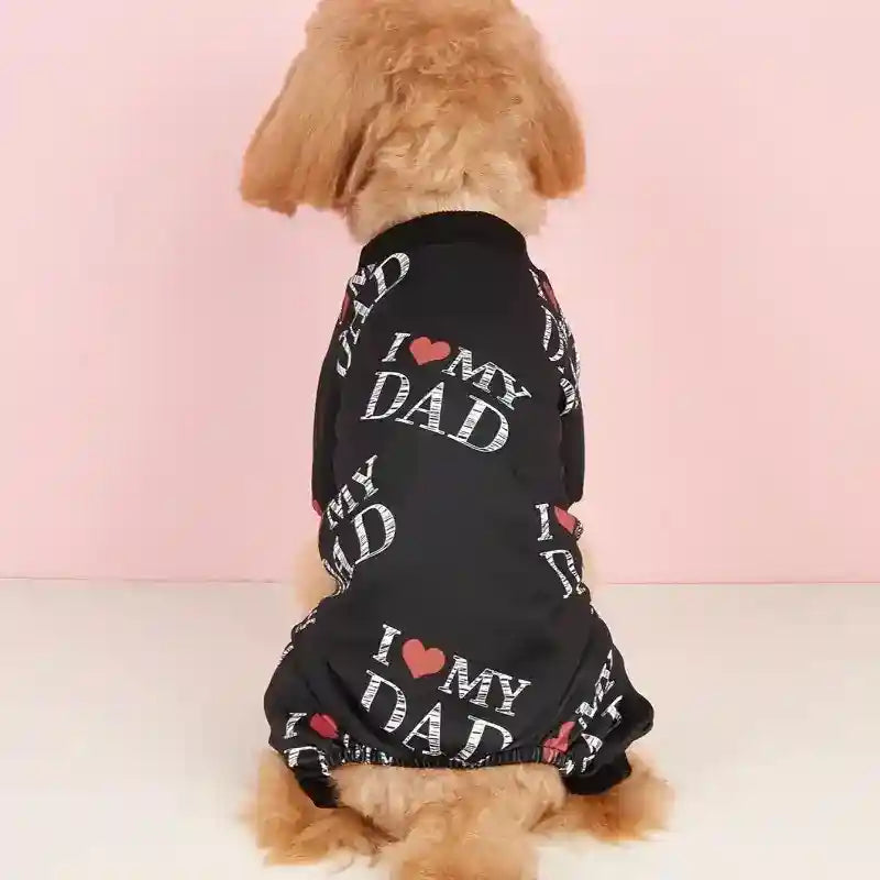 Small brown dog wearing black pet shirt with repeating I love my dad text against pink background