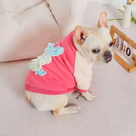 French Bulldog wearing pink and cream dinosaur costume sitting on carpet with calendar showing September 10
