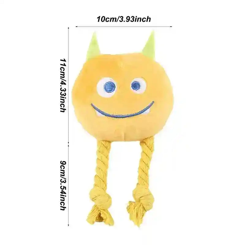 Yellow plush monster dog toy with green horns, blue eyes, smiling face, and rope legs