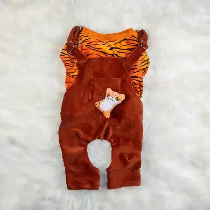 Brown corduroy baby overalls with tiger-striped orange shirt and plush tiger toy on white fuzzy background