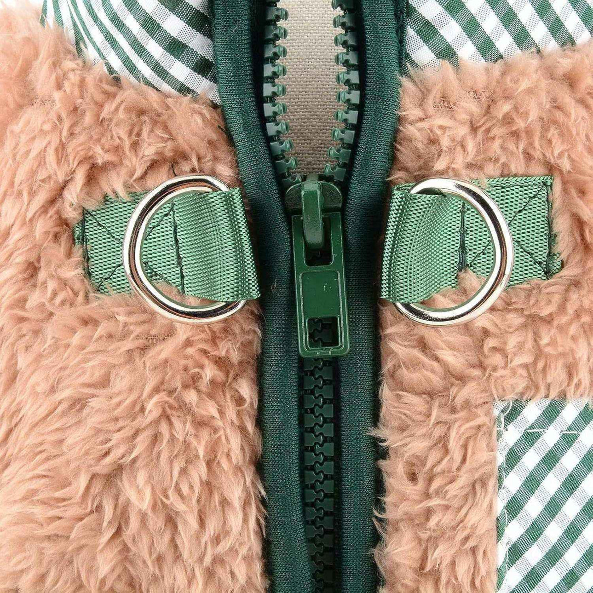 Close-up of green zipper on tan fuzzy fabric with green webbing straps and silver D-rings