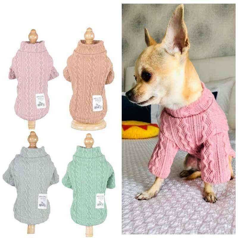 Small dog wearing pink cable knit sweater; also four similar sweaters in pink, camel, gray, and green colors displayed