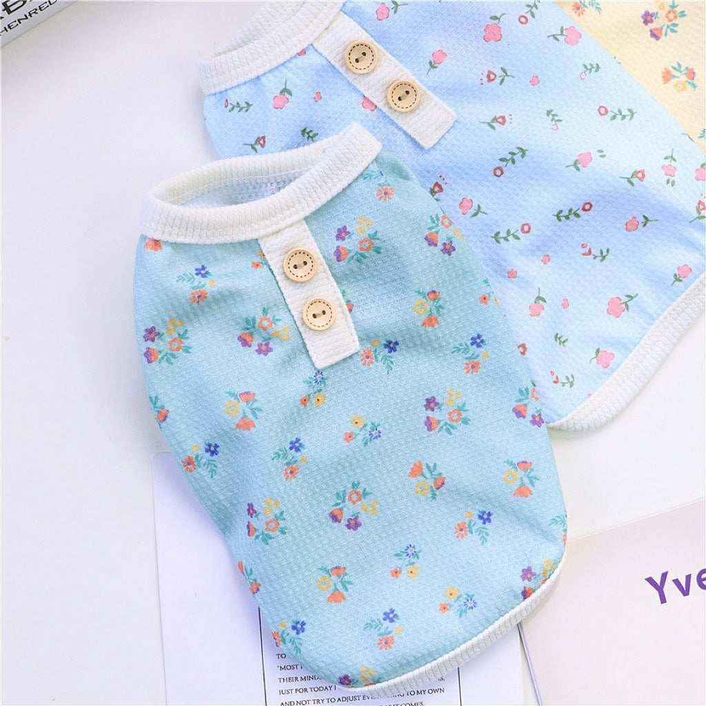 Two light blue pet shirts with colorful floral prints and wooden buttons on white trim collars