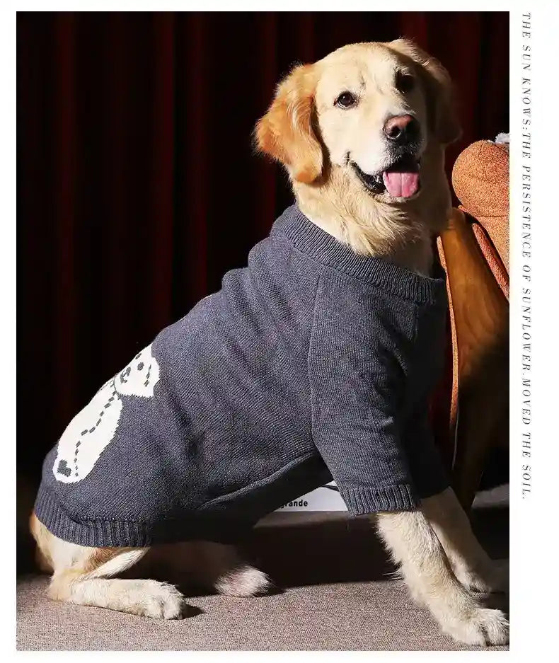 Golden retriever dog wearing gray knit sweater with white cat design indoors