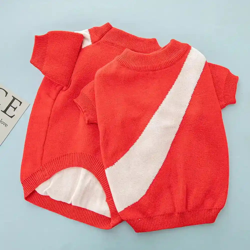 Two red knit dog sweaters with white diagonal stripe on blue background