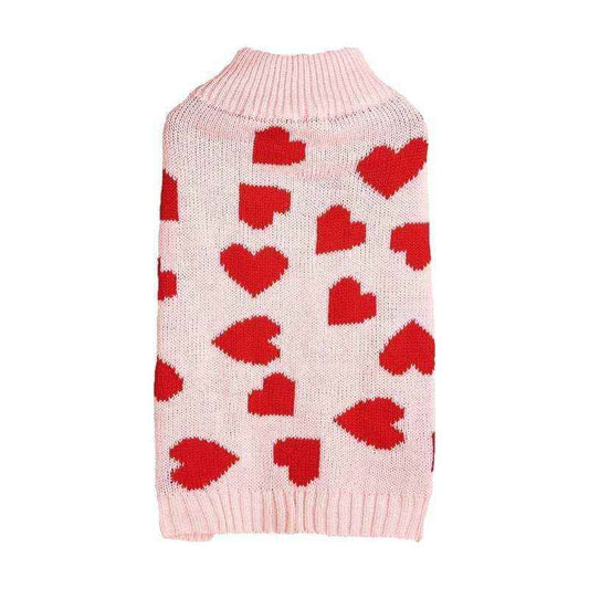 Pink knitted dog sweater with red heart pattern and ribbed collar and hem