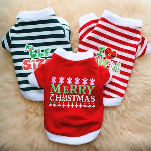 Three Christmas-themed pet sweaters with festive slogans, green and white, red and white stripes, on a beige furry background