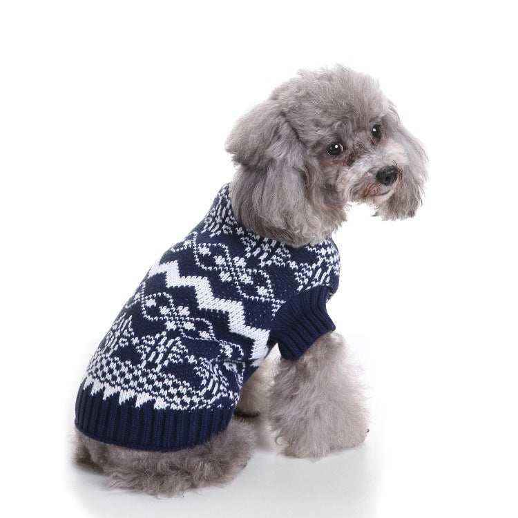 Small gray poodle wearing a navy blue and white patterned knit dog sweater sitting on white background