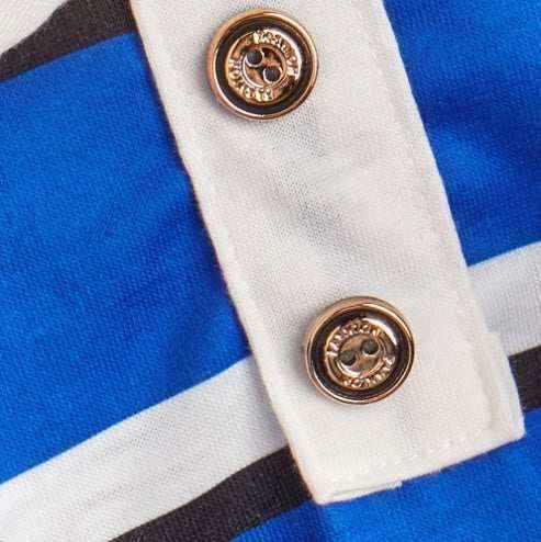 Close-up of a blue and white striped fabric with white button placket and branded metal buttons