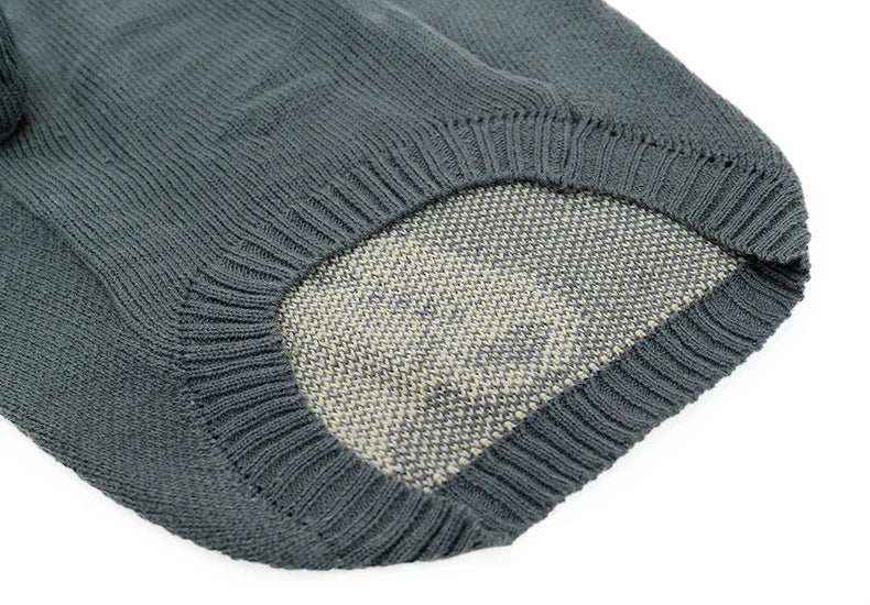 Close-up of a gray knitted sweater sleeve with contrasting inner texture and ribbed cuff