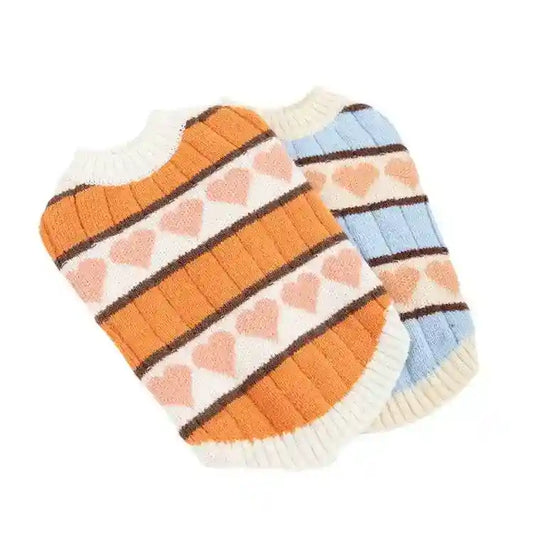 Two knitted pet sweaters with heart patterns, one orange and one light blue, ribbed edges