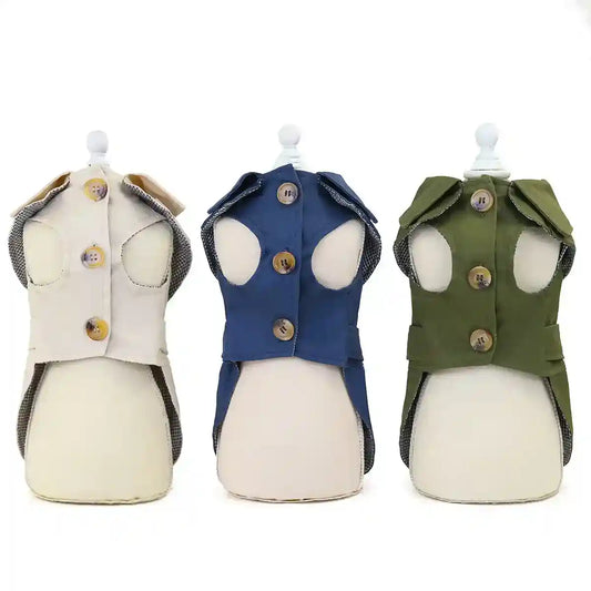 Three sleeveless dog coats in beige, navy, and olive green with button closures on white mannequins