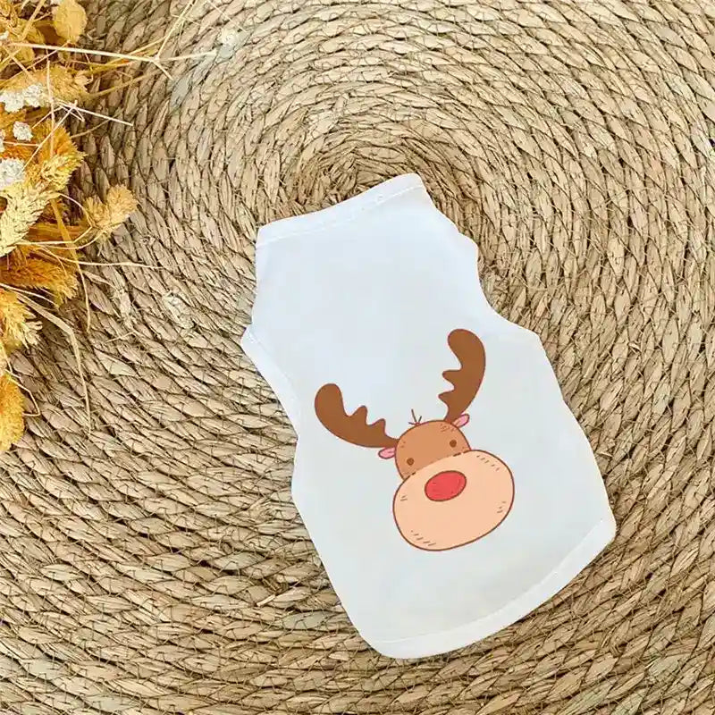 Small white pet shirt with cute cartoon reindeer print on woven natural mat background