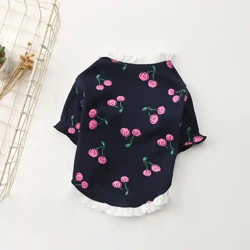 Navy blue pet shirt with pink cherry print and white lace trim on collar and hem