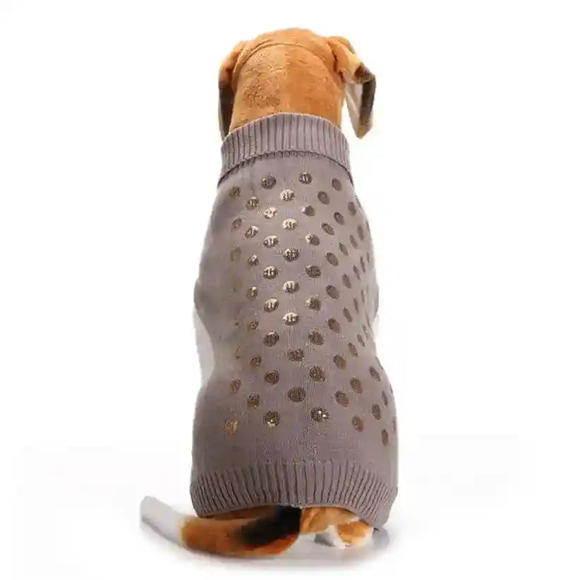 Dog wearing gray sweater with gold polka dots, sitting facing away on white background