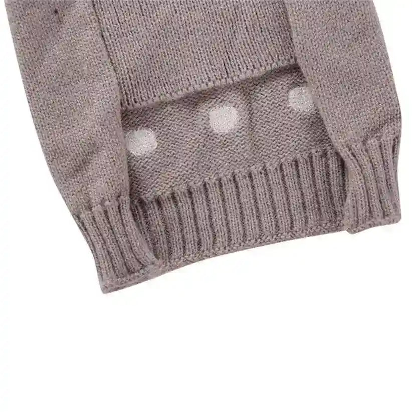 Close-up of mauve knitted sweater sleeve with ribbed cuff and white polka dot pattern