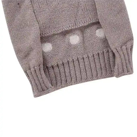 Close-up of mauve knitted sweater sleeve with ribbed cuff and white polka dot pattern