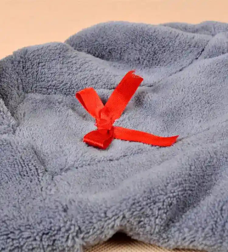Soft gray fleece fabric with a tied red ribbon on a light wooden surface