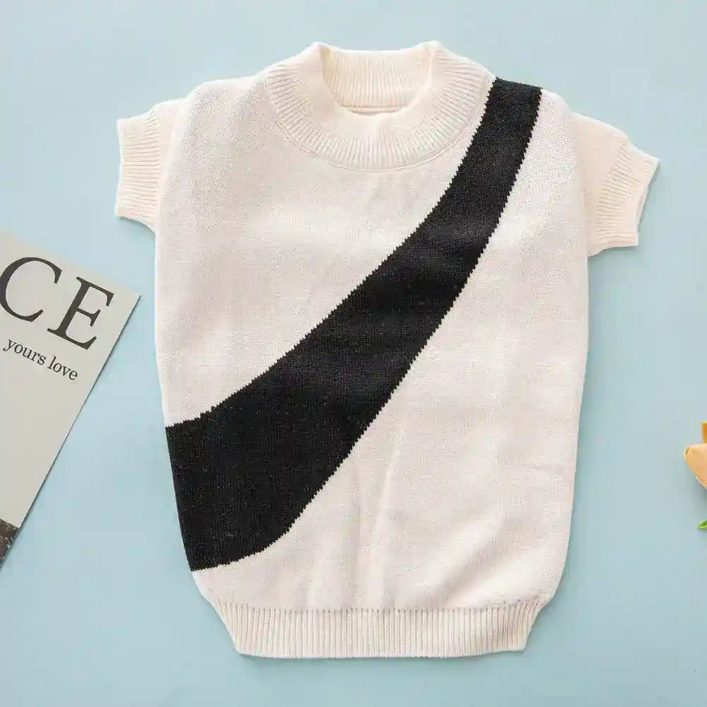 Cream knit short sleeve sweater with black diagonal stripe on light blue background
