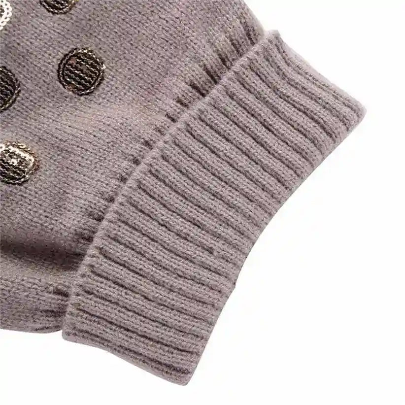 Close-up of gray knitted sweater cuff with metallic sequin polka dot accents