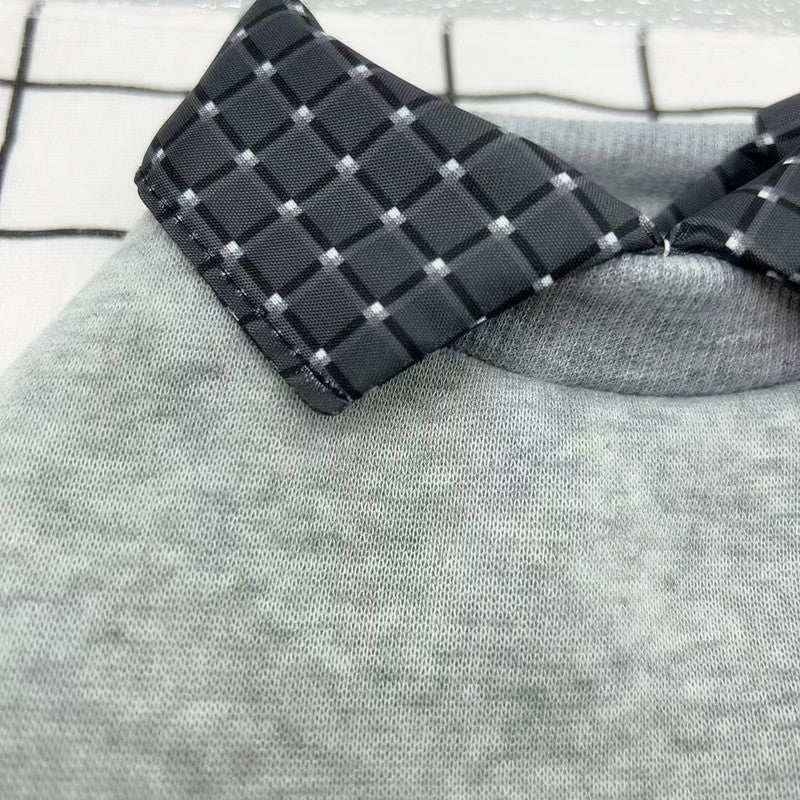 Close-up of gray knit fabric with black and white checkered collar detail on clothing