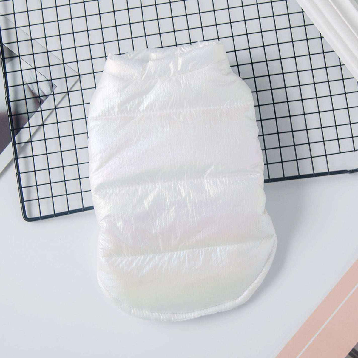 White disposable pet diaper on black grid surface, lightweight and padded