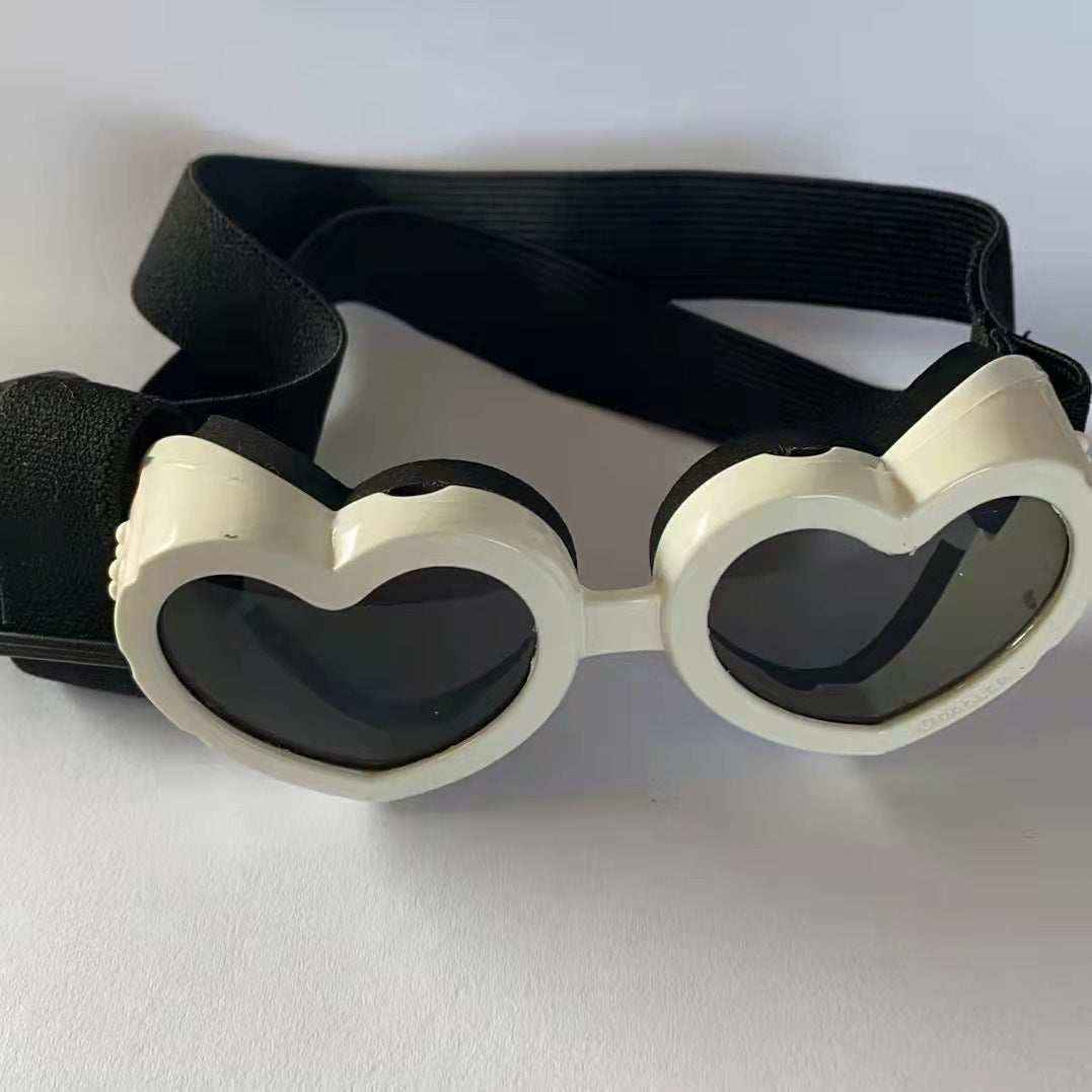 White heart-shaped goggles with dark lenses and an adjustable black strap