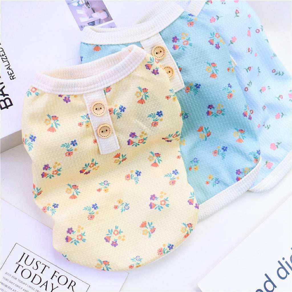 Two small floral print pet shirts in yellow and blue with buttons and white trim