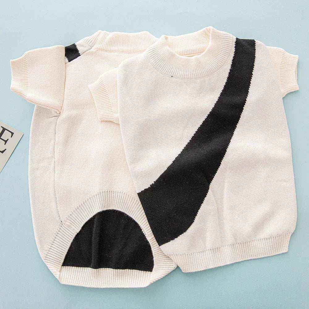 cream pet sweater with short sleeves and black diagonal stripe, laid flat on blue background