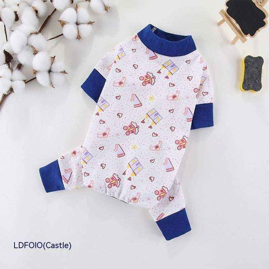 White dog onesie with blue cuffs and collar featuring hearts, castles, and teddy bear patterns