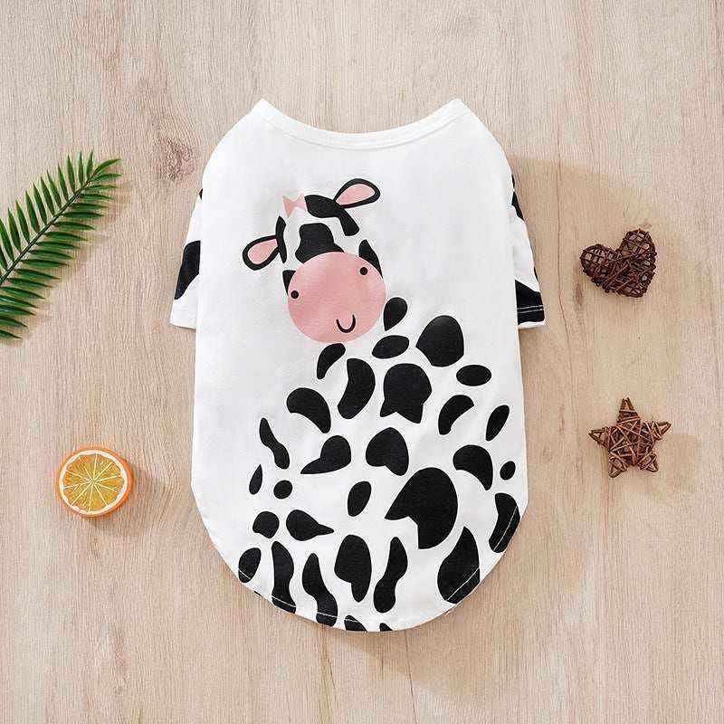 White pet shirt with cute black and white cow design and pink face on wooden background