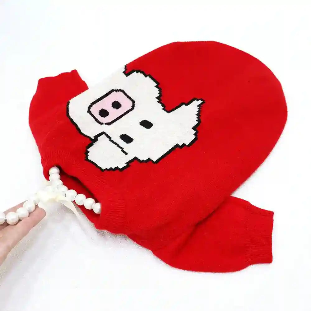 Red sweater with a pixelated white pig face design and pearl necklace on white background